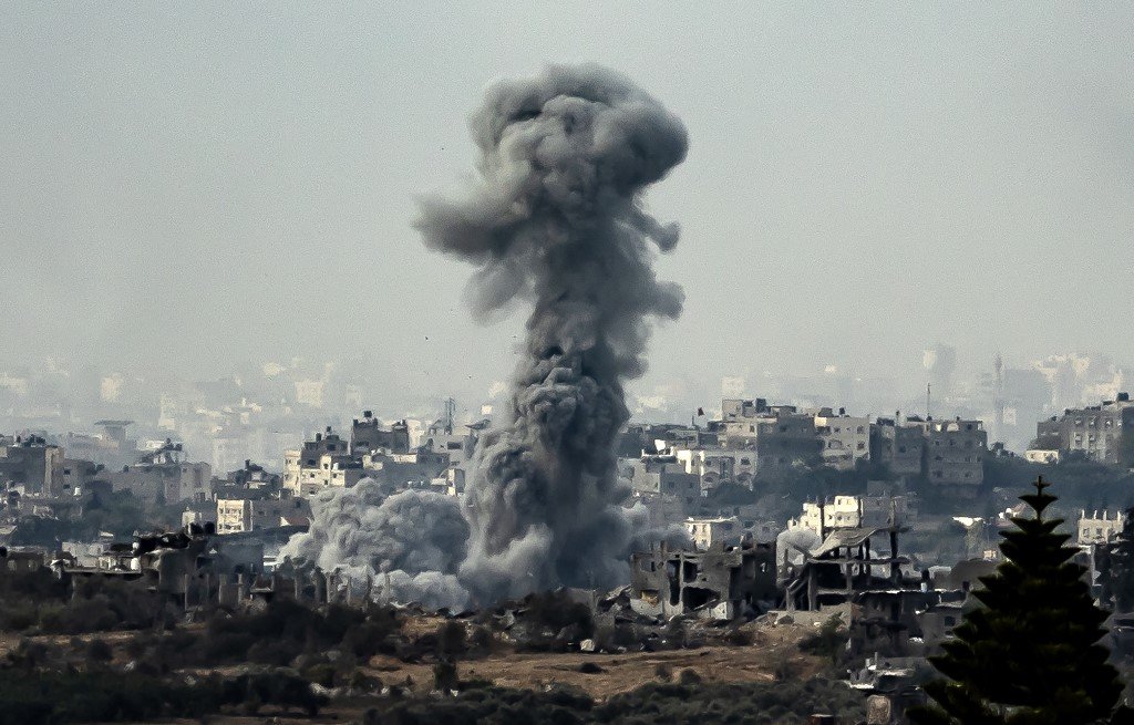 11月13日从以色列南部加沙地带边境拍摄的照片，显示以色列在持续战斗中轰炸加沙时喷发出的烟雾。（图取自法新社）